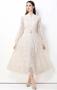 Détail d'une robe en dentelle ivoire élégante avec motifs floraux et ceinture assortie