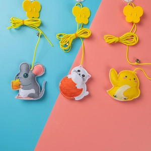 Detail of hanging felt cat toys in mouse and bird shapes with elastic strings and bells