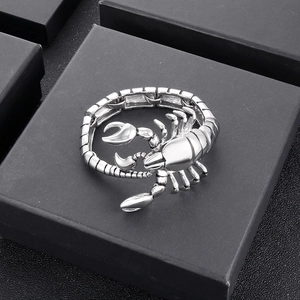 Detailed top view of a silver scorpion bracelet with movable joints on a black gift box