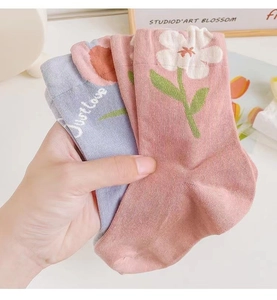 Close-up of floral cotton socks with tulip and daisy patterns and ribbed cuffs