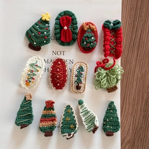 Detail of diverse handmade crochet Christmas tree and gift hair clips on white paper