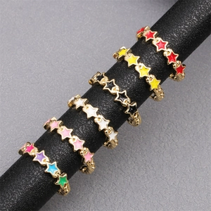 Detail of colorful enamel star rings with zircon inlay displayed on a black stand