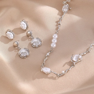 Baroque pearl jewelry set with necklace and earrings on beige silk fabric background