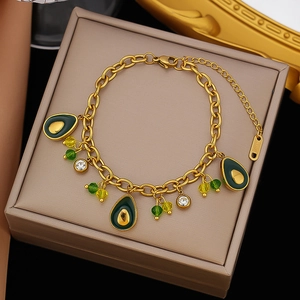 Gold stainless steel bracelet featuring turtle and green enamel charms on jewelry box