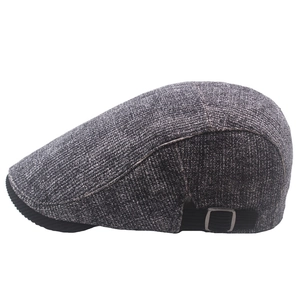 Détail de la boucle métallique réglable et de la sangle sur une casquette gavroche