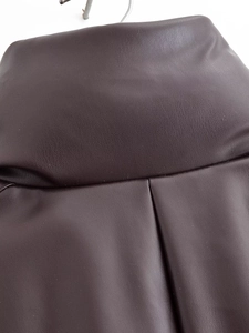 Détail du tissu en cuir marron foncé avec plis souples et texture lisse haut de gamme