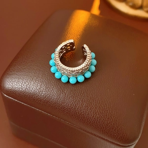 Dettaglio macro di orecchino vintage argento con perle turchesi su base in pelle