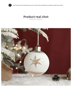 Close-up of a white frosted Christmas ball with star cutouts on a warm festive background