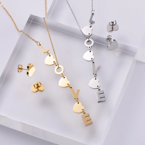 Golden and silver heart jewelry set with LOVE letter pendant on acrylic stands