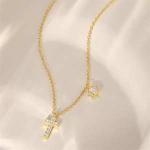 Detailed view of 925 silver gold-plated cross and flower pendants on a delicate chain