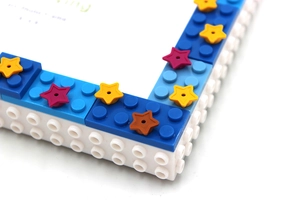 Macro close-up of blue and white DIY building block photo frame corner with star details