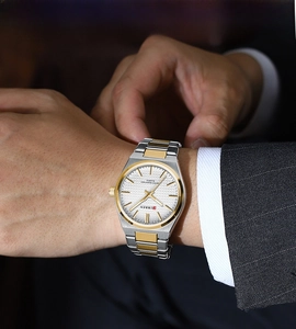 Close-up of luxury business quartz watch with two-tone band worn with a suit