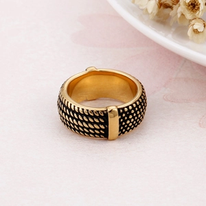 Detail of vintage gold-plated wide ring with black textured woven patterns and rivets