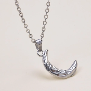 Macro shot of silver crescent moon necklace with unique hammered texture and slim chain