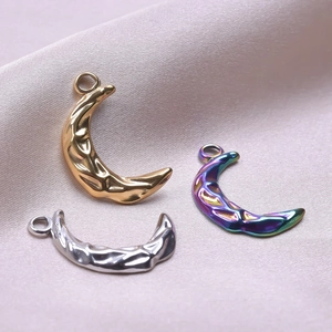 Macro shot of hammered moon pendants in gold, silver, and rainbow finishes