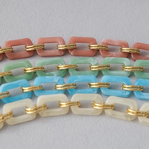 Macro shot of colorful marble resin links with gold metal rings for handbag straps