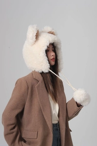 Detailed view of the soft faux fur bucket hat with bear ears and fuzzy pompom ties