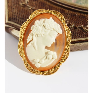 Vintage gold-framed cameo brooch necklace featuring a 3D relief lady portrait on peach base
