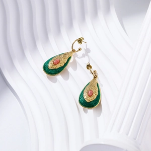 Detail of teardrop gold leaf earrings with green enamel and pink oval gemstone inlay