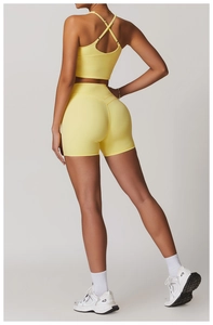 Dettaglio del reggiseno sportivo giallo limone con incrocio e pantaloncini yoga