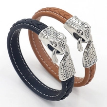 Detail of dark blue and brown woven leather bracelets with silver metal snake head clasps