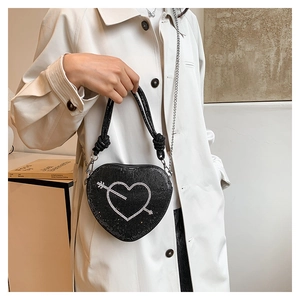 Dettaglio della borsa a cuore nera con strass e motivo a freccia sul cuore su cappotto