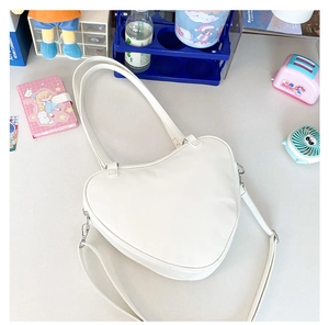 Close-up of white heart-shaped JK Lolita bag with metallic zipper and slender shoulder strap