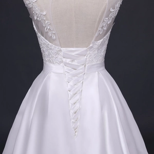 Detailansicht eines Brautkleides mit Spitzenstickerei und eleganter Schnürung am Rücken