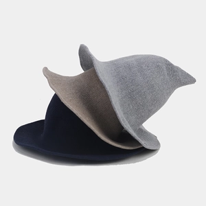 Detailed knitted texture of foldable wizard hats in navy, beige, and grey colors