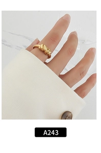 Close-up of a golden twisted woven ring on a finger, featuring model A243 minimalist style