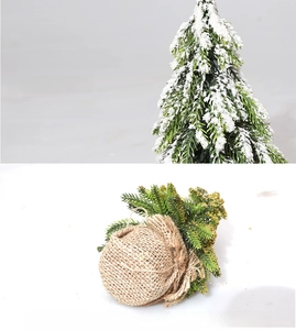 Close-up of mini flocked Christmas tree with snowy needles and a stable burlap base