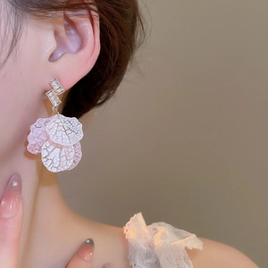Detail of layered petal drop earrings with zircons shown on a model's ear profile