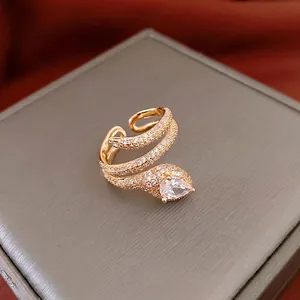 Gold plated snake ring with pavé zircons and a pear-cut stone on a jewelry box