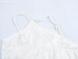Detail of white satin camisole with adjustable spaghetti straps and elasticated neckline