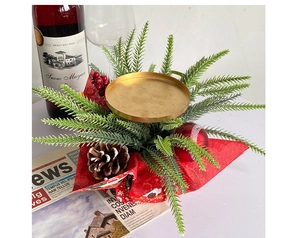 Close-up of Christmas candle holder with red berries, pine cones and gold metal tray