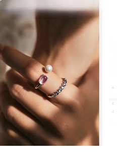 Close-up of minimalist S925 silver rings set with moonstone and pearl on finger