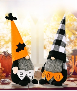 Close-up of Halloween gnomes holding a BOO banner with festive pumpkin decorations