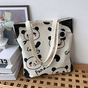 Detail einer Panda Canvas Tasche auf einer Holzbank mit künstlerischem Hintergrund