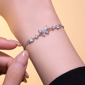 Exquisite silver bow bracelet with sparkling zircons worn on wrist, minimalist style