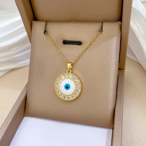 Detailed close-up of a gold Evil Eye necklace with crystals in a luxury gift box