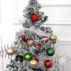 Christmas ball ornament set with red, gold, and green Baubles hanging on a snowy tree