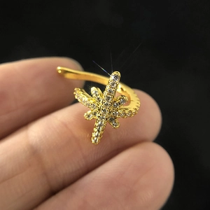 Macro detail of a gold cartilage ear cuff with micro-pave star shaped sparkling zircons