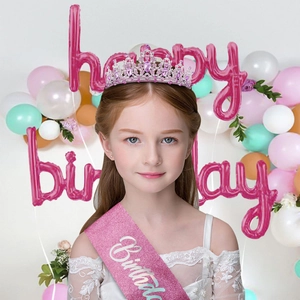 Close-up detail of a young girl wearing a pink crystal tiara and a birthday sash accessory