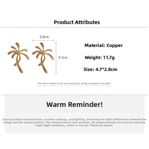 Close-up of gold palm tree earrings with silver needles showing 4.7x2.8cm dimensions
