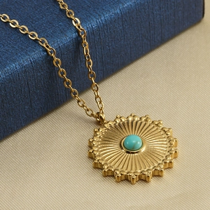 Golden stainless steel necklace featuring a lace sun pendant with a round turquoise stone