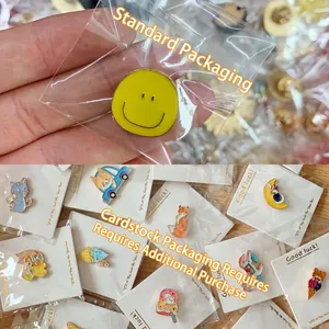 Cute cartoon animal enamel pins featuring smiley face, cat and bear designs in packaging