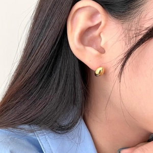 Close-up of minimalist gold bean stud earrings in S925 sterling silver on model