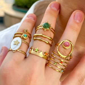 Golden stainless steel rings set with natural white shell and colorful gemstones on fingers