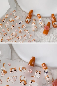 Macro detail of 3D embossed orange cat nail art stickers with cute paw print elements