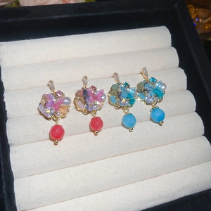 Detail view of crystal floral and butterfly earrings with pearls in a luxury display case